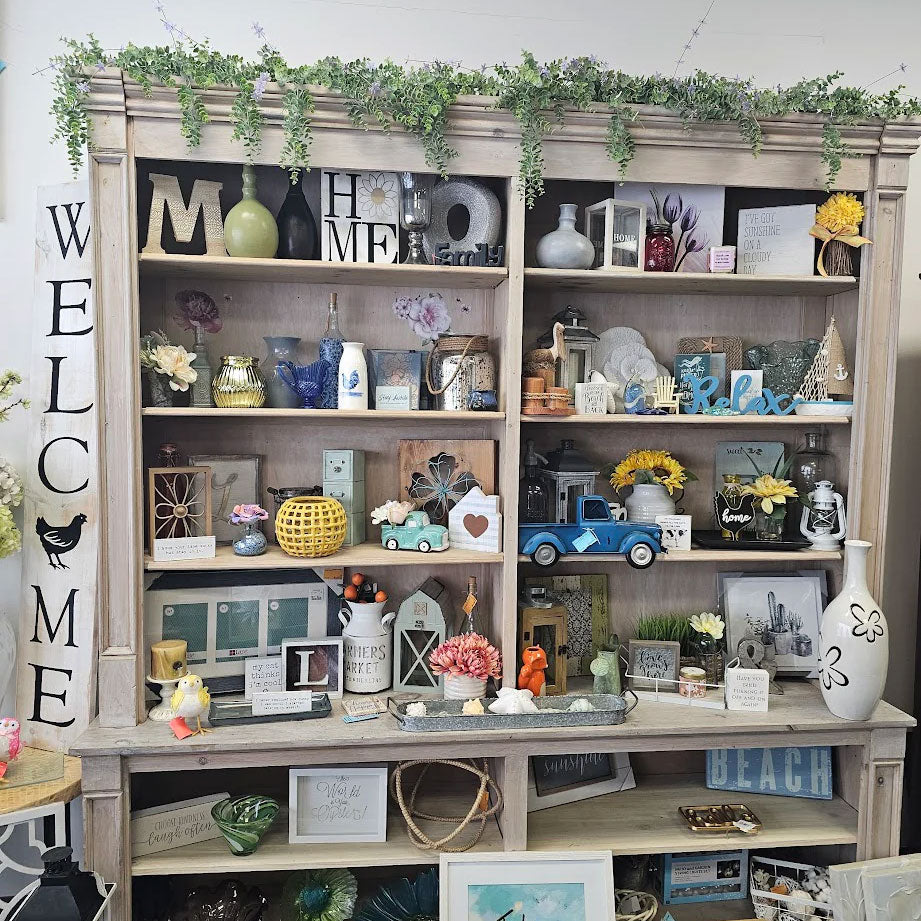 Decorative bookshelf with various items including vases, figurines, and framed pictures.